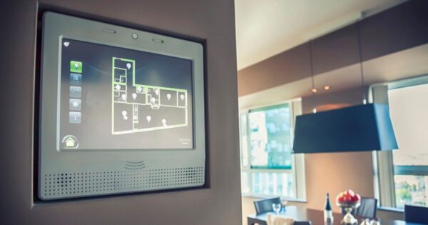 Der Bildschirm eines Smart Home Systems ist an einer Wand im Esszimmer befestigt.