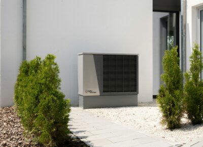 sanierung reihenfolge, moderne Luft Wasser Wärmepumpe neben einem Wohnhaus