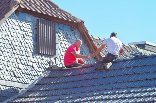 Handwerker arbeiten auf dem Dach eines Wohnhauses
