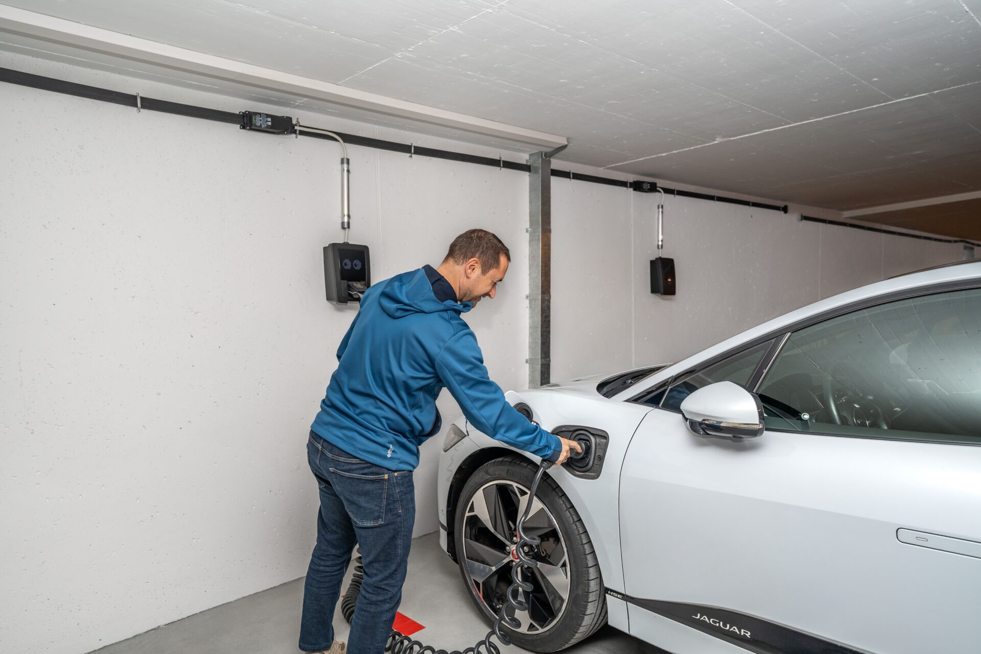 Mann lädt ein Elektroauto in einer privaten Garage