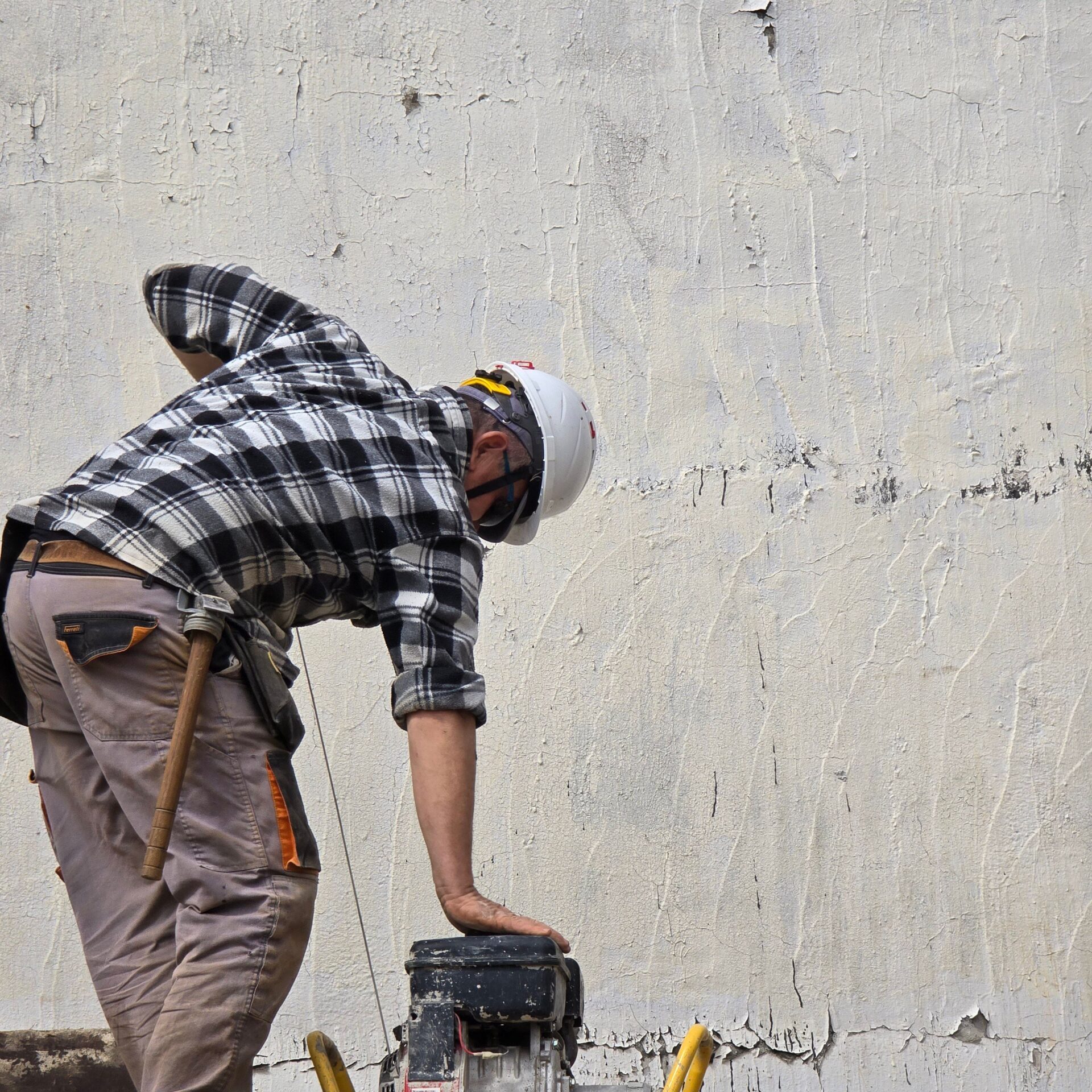 Handwerker arbeitet bei einer Renovation an einer Hauswand