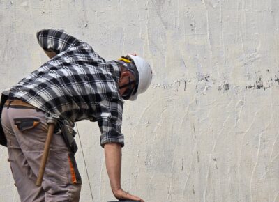 Handwerker arbeitet bei einer Renovation an einer Hauswand
