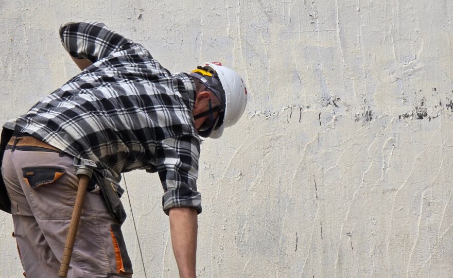 Handwerker arbeitet bei einer Renovation an einer Hauswand