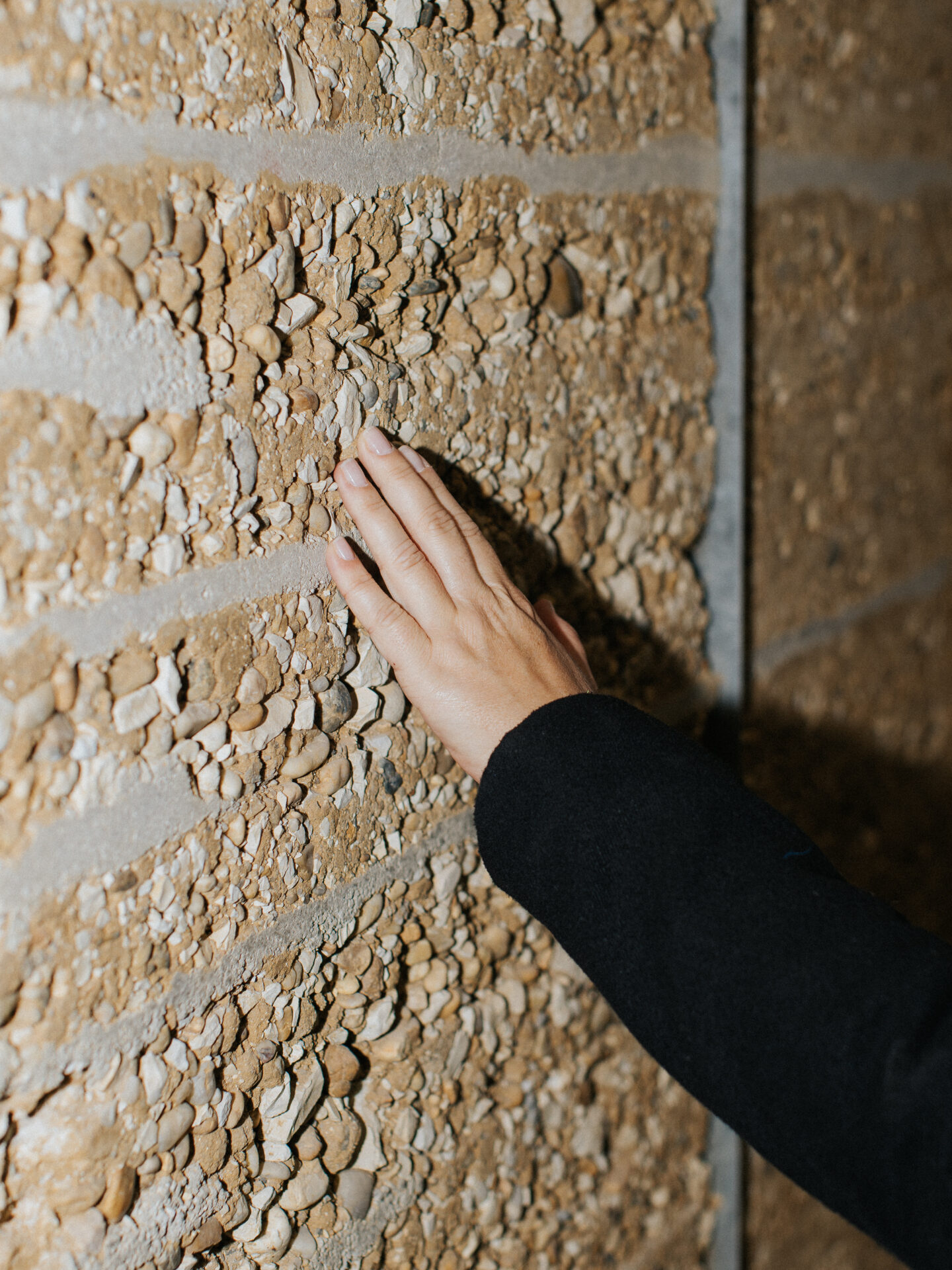 Material Hand auf einer strukturierten Wandoberfläche