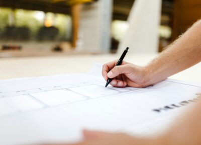 Hand mit Stift auf einem Bauplan