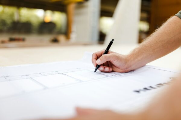 Hand mit Stift auf einem Bauplan