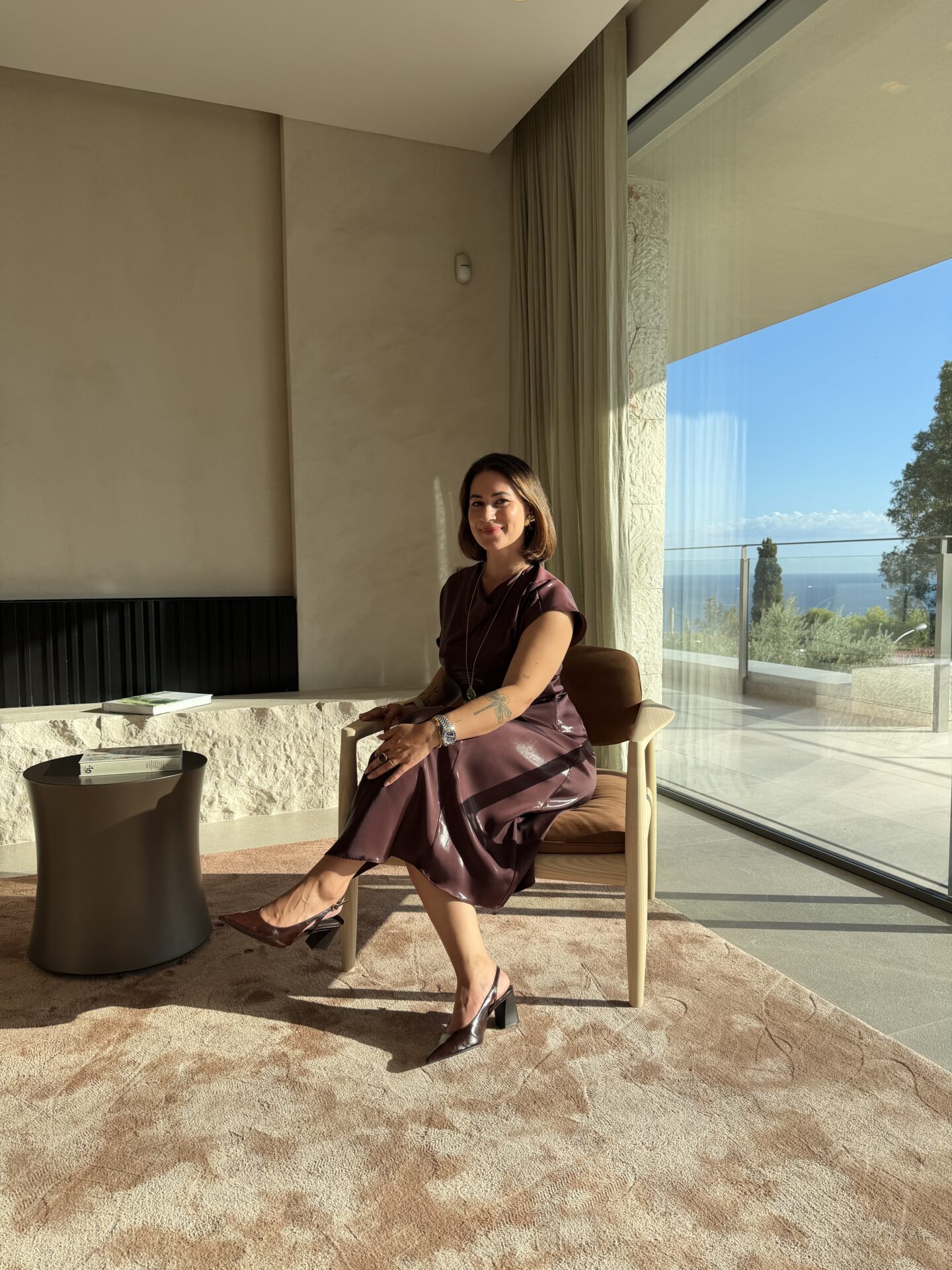 Anisa Imhof sitzt in einem Wohnraum vor einer grossen Fensterfront