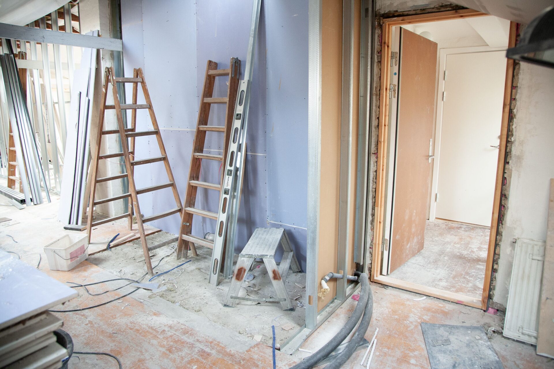 Wohnungsinnenraum im Umbau mit offenen Wandkonstruktionen, Leitungen und Leitern