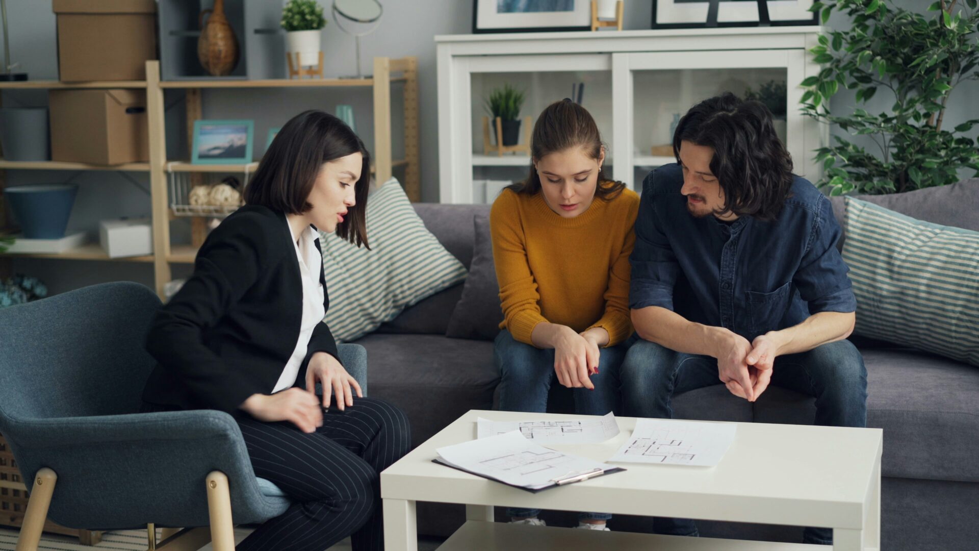 Drei Personen besprechen Pläne für Veränderungen in einer Wohnung